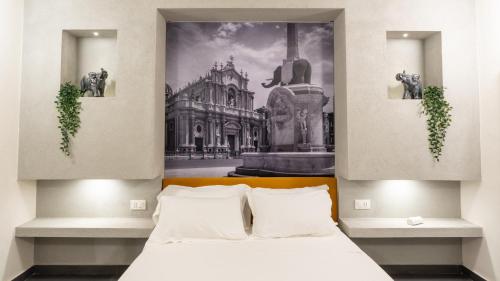 a bedroom with a bed and a painting on the wall at Aetna LuxurySuites in Catania