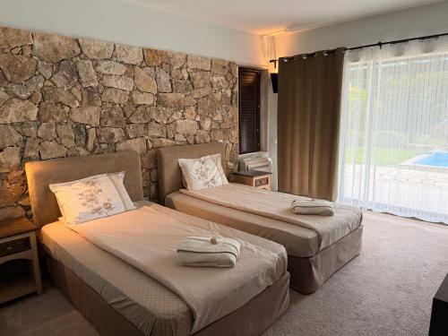 two beds in a room with a stone wall at Luxury villas and golf GV6 in Balchik