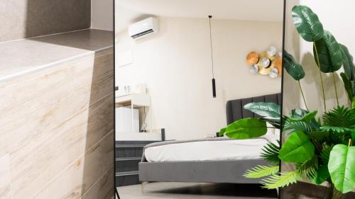 a bedroom with a bed and a plant at Aetna LuxurySuites in Catania