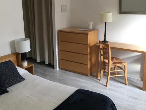 a bedroom with a desk and a bed and a chair at Le Clos Nicolas in Eugénie-les-Bains