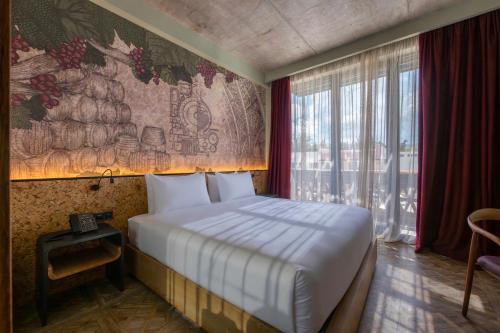 a bedroom with a bed and a large window at The Wine Station in Tsinandali