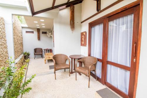 a patio with chairs and a table and a door at Cocotinos Lembeh a Boutique Dive Lodge in Bitung