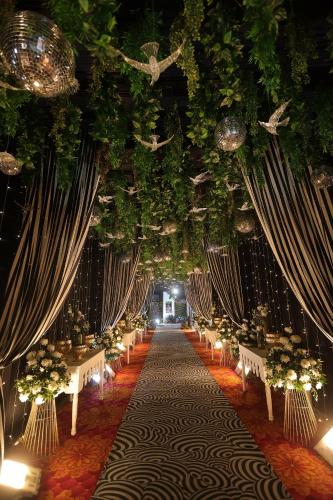 a long aisle with tables and chairs and lights at Chhapaak Resort in Patna