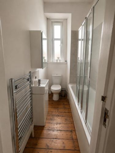 a bathroom with a toilet and a sink and a window at Comfortable 2 Bedroom Flat in Leith in Edinburgh