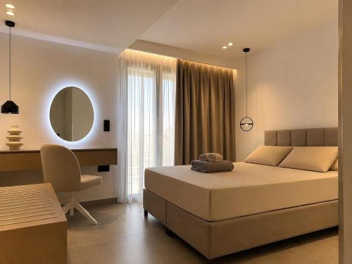 a bedroom with a bed and a desk and a mirror at VITHΟS SUITE Luxury Living in Virós