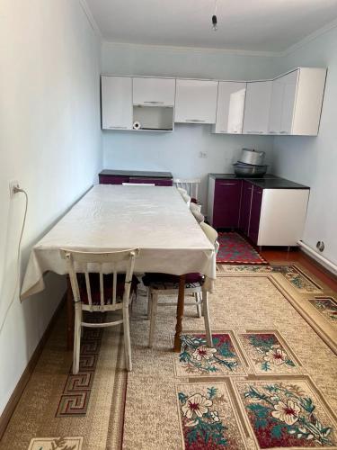 a kitchen with a table and chairs in a room at Aimir in Akchiy