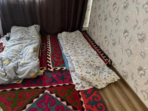 an unmade bed in a room with a rug at Aimir in Akchiy