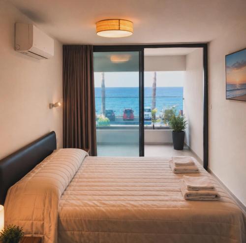 a bedroom with a bed with a view of the ocean at Amalia Apartments in Polis Chrysochous