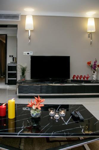 a living room with a large flat screen tv at Red Mango Hotel and Apartments in Takoradi