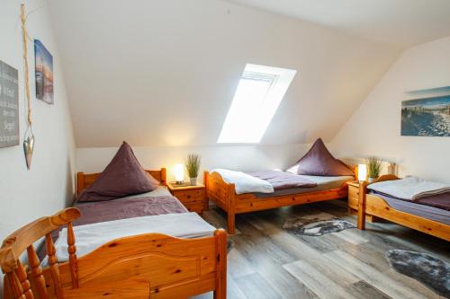 a room with three beds and a window at Ferien- und Pferdehof Egelkraut "Feriendomizil am Meer" in Wangerland