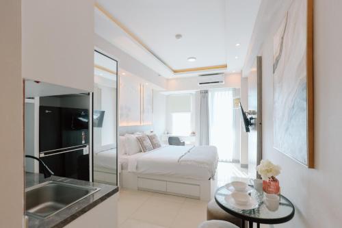 a bathroom with a bed and a sink in a room at Yoonah at Benson Pakuwon Mall in Lontar