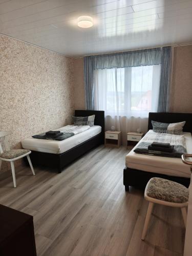 a bedroom with two beds and a window at Apartments Feniks in Blomberg