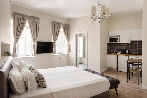 a bedroom with a large bed and a kitchen at Suites Guest House in Cascais