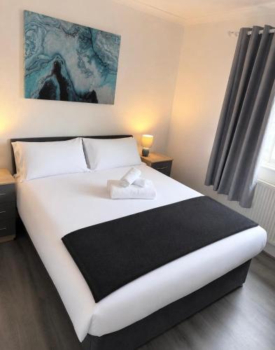 a bedroom with a large white bed and a window at Large 4-Bedrooms Corporate Flat, Free Parking - Amazing Location in Leavesden Green