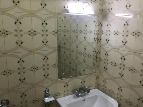 a bathroom with a sink and a mirror at Nalanda Tulip in Kolkata