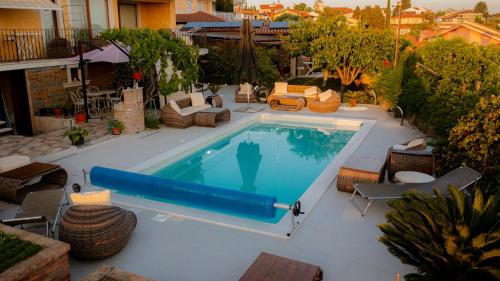 a large swimming pool with chairs and a blue pool noodle at Rooms Apartim 2 Piran in Piran