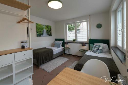 a small room with two beds and a table at Sali Homes - GaesteHaus Lamm Obersulm in Obersulm