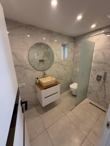 a bathroom with a sink and a toilet and a mirror at ORDAMS Villa in Himare