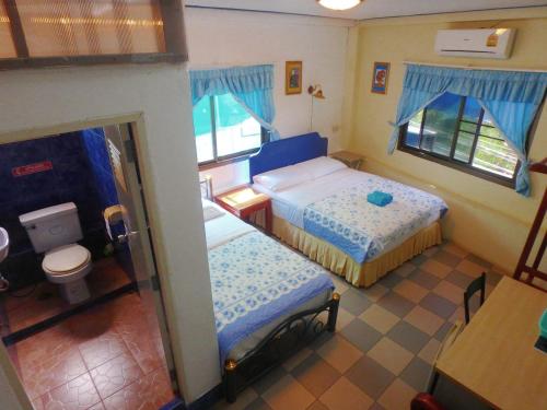 a small bedroom with two beds and a toilet at Residence House in Trat