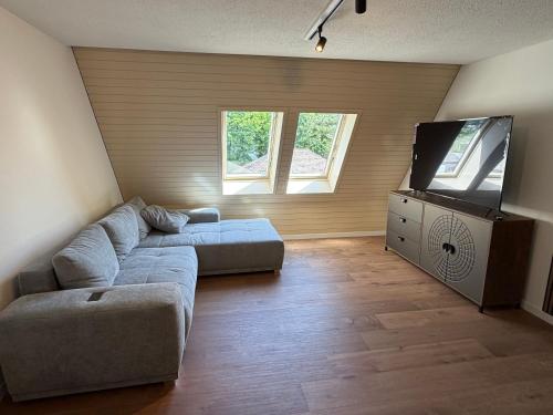 a living room with a couch and a flat screen tv at City Apartments in Brunnen