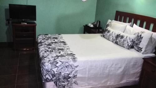a bedroom with a bed with a black and white blanket at Gloria's Bed and Breakfast in Livingstone