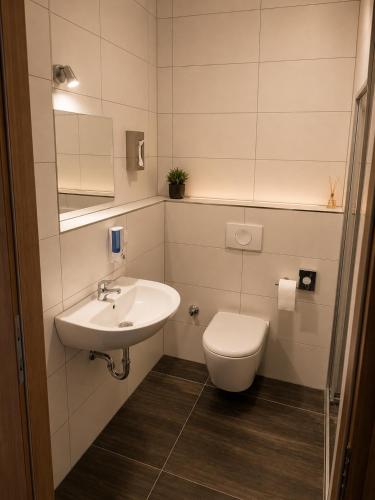 a white bathroom with a toilet and a sink at Hotel Pasa Paradies KOSTENLOSE PARKPLÄTZE in Hanau am Main
