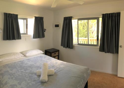 a bedroom with a bed with two white towels on it at Russell-Orongo Bay Holiday Park in Russell