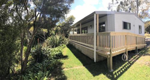 a modular home with a wrap around deck in a yard at Russell-Orongo Bay Holiday Park in Russell