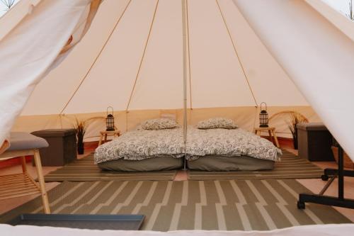 a bedroom in a tent with a bed in it at Mardi talu Glamping in Paekna
