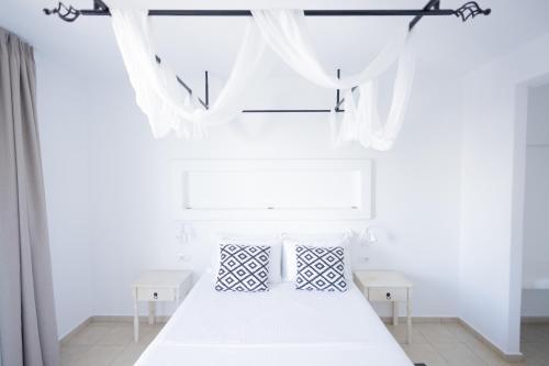 a bedroom with a white bed with white curtains at Harmony Hotel in Sarandë