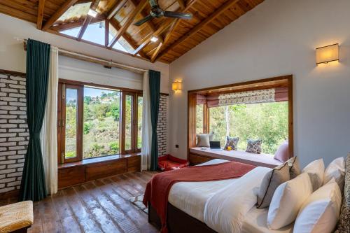 a bedroom with a large bed and a large window at SaffronStays Brookside Estate in Rānīkhet