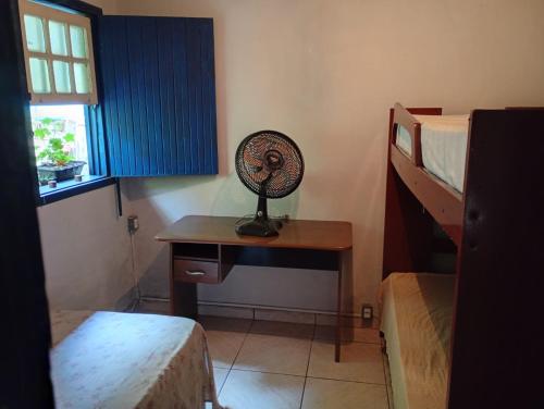 a room with a desk and a fan on a table at Casa da tranquilidade in Ouro Preto