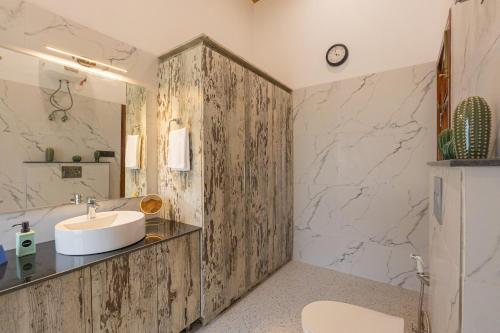 a bathroom with a sink and a counter top at SaffronStays Brookside Estate in Rānīkhet