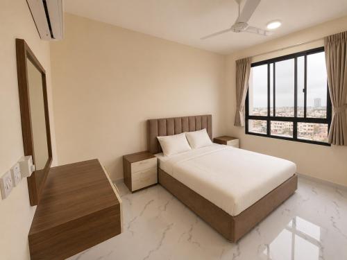 a bedroom with a bed and a large window at RED Gardenia in Salalah