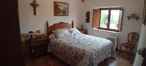 a bedroom with a bed and a cross on the wall at Stone Cottage FISTERRA in Curtis
