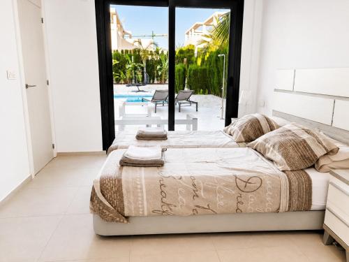 a bedroom with a large bed and a pool at La Perla Blanca in Benijófar