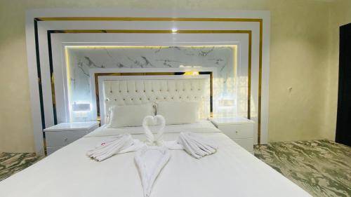 a bedroom with a white bed with a bow on it at Al Raiyan Serviced Apartments in Taif