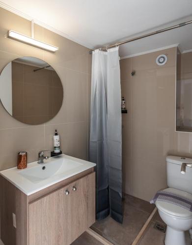 a bathroom with a sink and a toilet and a mirror at Naiades Hotel by Estia in Kato Gouves
