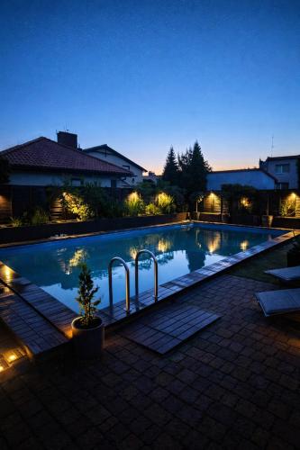 a swimming pool lit up at night with lights at Villa Aqua Wągrowiec Pool House in Wągrowiec