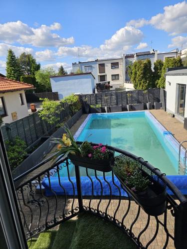 a balcony with a swimming pool with plants on it at Villa Aqua Wągrowiec Pool House in Wągrowiec