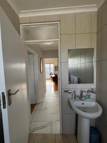 a bathroom with a sink and a mirror at T&A Escape in Grassy Park