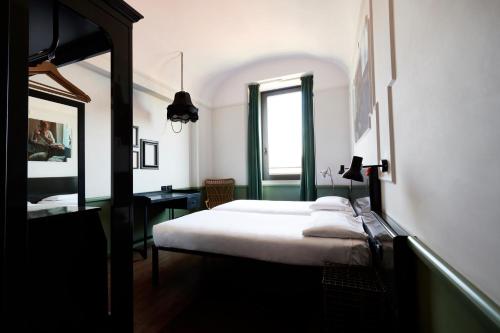 ein Schlafzimmer mit einem weißen Bett und einem Fenster in der Unterkunft Generator Rome in Rom