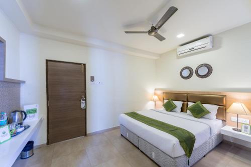 a bedroom with a large bed and a ceiling fan at Treebo Nestlay Airport Alandur in Chennai