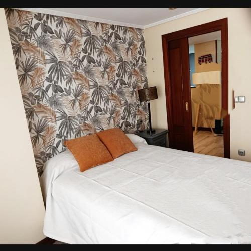 a bedroom with a white bed with a wall at Apartamento céntrico Irene IV in Avilés