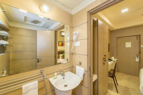 a bathroom with a sink and a mirror at Treebo Nestlay Airport Alandur in Chennai