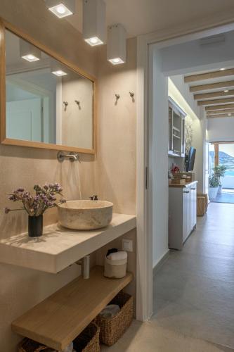 a bathroom with a sink and a mirror at Michalakis Seaside Suites in Pollonia