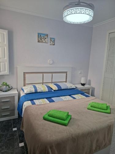 a bedroom with two beds with green towels on them at Casas Holiday - Puerto Romano in La Mata