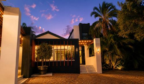 a house with a gate and a palm tree at Alimandi Villa in Klapmuts