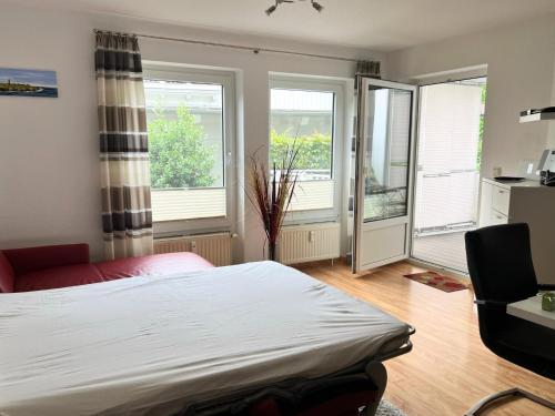 a bedroom with a bed and two windows and a desk at Komfortable Ferienwohnung mit Terrasse auf Fehmarn in Fehmarn