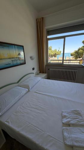 a bedroom with three beds and a large window at hotel cri cri - fronte spiaggia in Silvi Marina